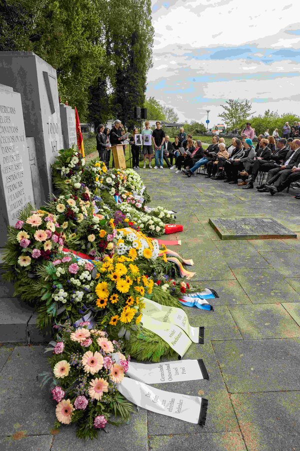 Bild vergr&ouml;&szlig;ern: Gedenkveranstaltung mit Blumengestecken vor einem Gedenkstein