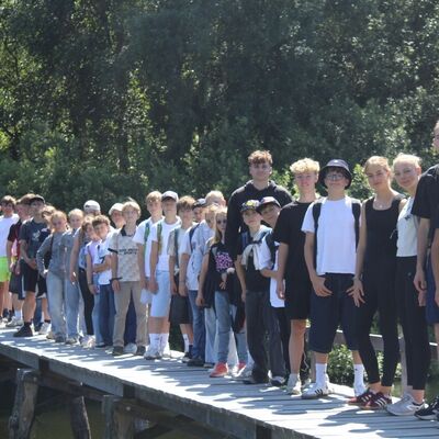 Bild vergr&ouml;&szlig;ern: Eine Gruppe Kinder und Jugendlicher stehen auf einem Holzsteg am See