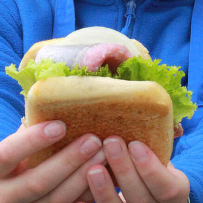 Bild vergr&ouml;&szlig;ern: Frau mit Matjesbr�tchen in der Hand